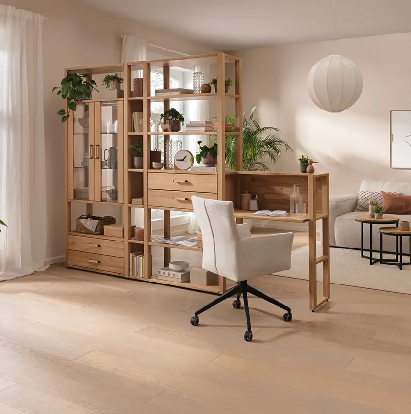 Modernes Homeoffice mit offenem Regal aus Holz, integriertem Schreibtisch und Drehstuhl. Funktionale Wohnlösung für Arbeiten im Wohnzimmer mit Stauraum, Pflanzen und natürlichem Design in hellen Farben.